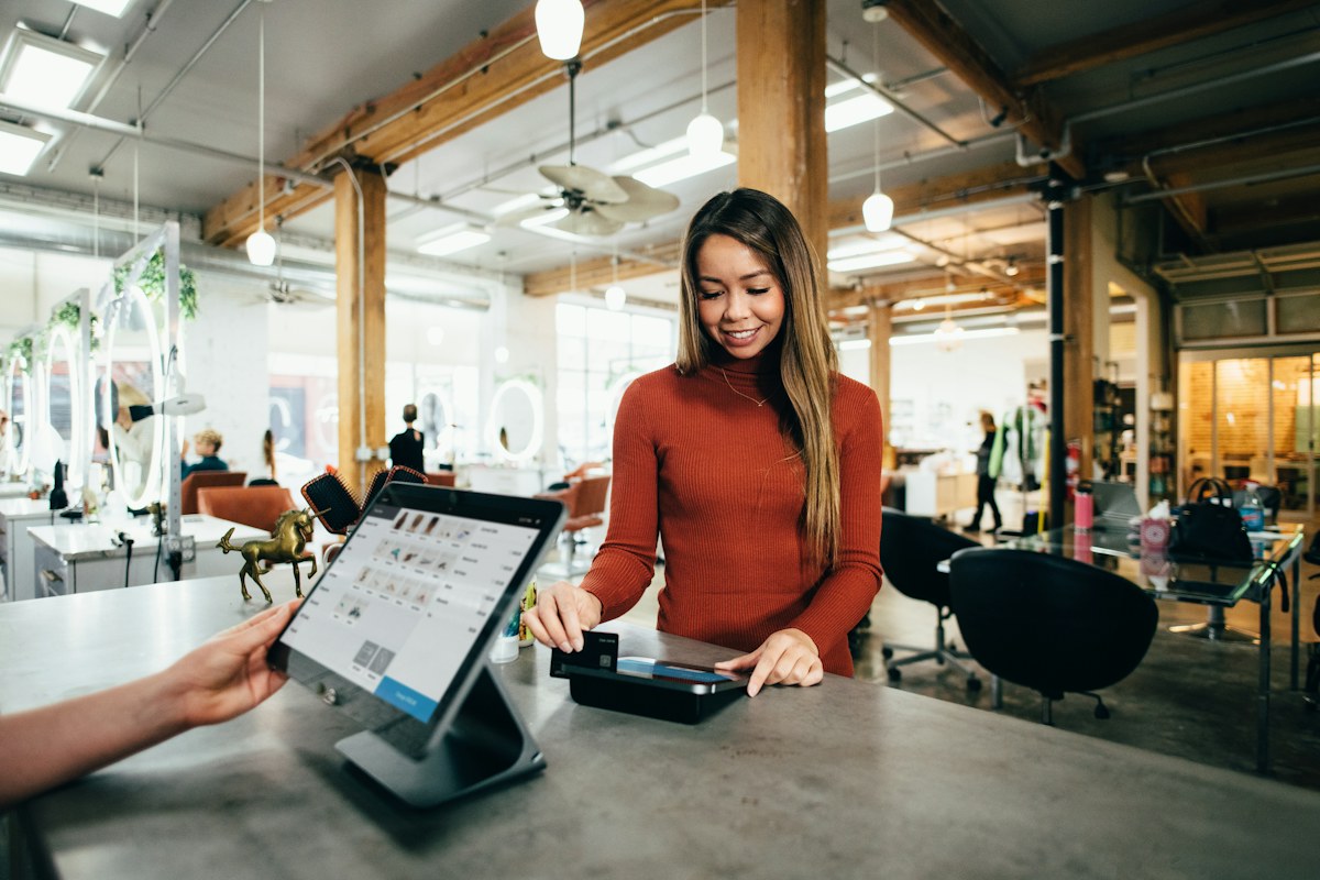 A customer completing a purchase at a retail counter using a payment terminal